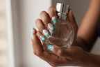 Dark skin hands holding perfume wearing teal floral bow custom press-on nails inclusive beauty — LuxepressCo