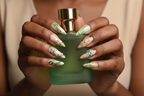 Dark skin hands holding green perfume bottle wearing dragonfly garden custom press-on nails sage green — LuxepressCo