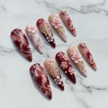 Hero studio shot full set 10 burgundy marble stiletto custom press-on nails white marble background — LuxepressCo