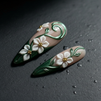 Macro close-up 3D white jasmine flowers gold bead centers emerald chrome leaf vine custom press-on nails dark background — LuxepressCo