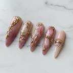 Macro close-up oval gold frame accent dusty rose stiletto custom press-on nails white marble — LuxepressCo