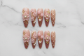 Flat lay top-down full set 10 luxury 3D floral pearl gold press-on nails marble background reusable nails — LuxepressCo