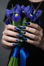 Light skin hands with royal blue chrome gothic gemstone stiletto reusable nails holding iris flowers — LuxepressCo