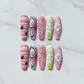 Flat lay top-down view all 10 spring garden press-on nails arranged symmetrically custom press-on nails studio photography — LuxepressCo