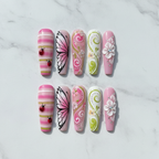 Flat lay top-down view all 10 spring garden press-on nails arranged symmetrically custom press-on nails studio photography — LuxepressCo