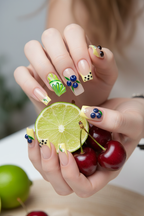 Fair skin hands wearing citrus French garden square custom press-on nails holding fresh lime and dark cherries — LuxepressCo