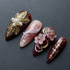 Macro close-up burgundy 3D gold floral pearl custom press-on nails dramatic lighting — LuxepressCo