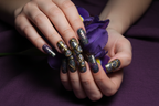 Fair-skin hands wearing galaxy purple teal custom press-on nails holding deep purple iris flower — LuxepressCo