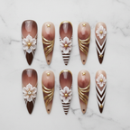Flat lay top-down full set 10 brown ombre 3D floral gold foil stiletto reusable press-on nails white marble — LuxepressCo