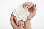Fair-skin hands wearing chrome aurora galaxy custom press-on nails holding white gardenia — LuxepressCo