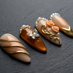 Macro close-up amber cognac butterfly crystal rhinestone custom press-on nails dramatic lighting — LuxepressCo