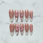Flat lay top-down 10 dusty rose pink magnolia gold filigree pearl custom press-on nails white marble — LuxepressCo