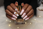 Dark skin hands holding perfume with Christmas reusable press-on nails inclusive pink winter — LuxepressCo
