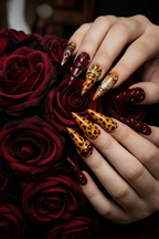 Light skin hands with burgundy amber leopard stiletto reusable nails holding dark red roses — LuxepressCo