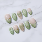 Sage green ombre French tip gold wire butterfly bow daisy clover charm custom press-on nails flat lay overhead marble — LuxepressCo