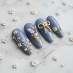 Macro close-up gold rope bow charm white flower pearl embellishments periwinkle blue almond press-on nails — LuxepressCo