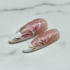 Macro close-up dusty rose French tip lily bloom gold vine reusable salon-quality nails marble background — LuxepressCo