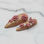 Close-up 3D rose pearl butterfly stiletto press-on nails texture gloss marble background salon-quality nails — LuxepressCo