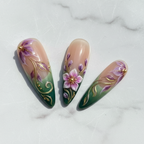 Macro close-up luxury floral press-on nails green nude gradient gold vine swirls glossy finish — LuxepressCo