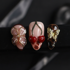 Macro close-up 3D gold enamel flower butterfly red resin cherry charm tortoiseshell almond custom press-on nails detail — LuxepressCo