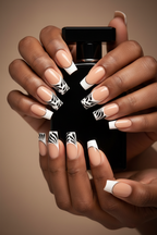 Dark-skin lifestyle nude peach black swirl feather custom press-on nails holding black perfume — LuxepressCo