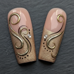 Macro close-up 3D gold metallic swirl rhinestone custom press-on nails dramatic lighting — LuxepressCo