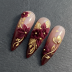 Macro close-up burgundy velvet 3D flower gold vine custom press-on nails dramatic lighting — LuxepressCo