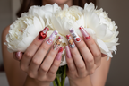 Light skin hands holding flowers with Valentine custom press-on nails salon-quality — LuxepressCo