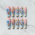 Flat lay top-down 10 blue floral pearl gold vine custom press-on nails white marble — LuxepressCo