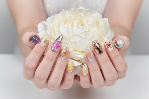 Fair-skin hands wearing aurora fantasy mermaid custom press-on nails holding iridescent white-gold peony — LuxepressCo
