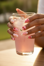 Dark skin hands wearing pink fruit 3D custom press-on nails holding pink lemonade — LuxepressCo
