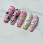 Macro close-up 3D ladybug charm pink stripe and rhinestone swirl floral custom press-on nails white marble — LuxepressCo