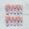 Flat lay top-down full set 10 lavender 3D flower gold vine French tip pearl salon-quality nails white marble — LuxepressCo