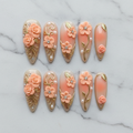 Flat lay top-down full set 10 3D rose gold filigree peach coral custom press-on nails overhead studio — LuxepressCo