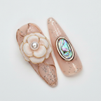 Macro close-up 3D camellia flower and rose gold shell frame salon-quality press-on nails nude base — LuxepressCo
