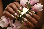 Lifestyle dark skin hands wearing gold armor blossom custom press-on nails holding pink magnolia — LuxepressCo