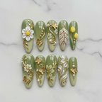 Flat lay top-down sage green 3D floral custom press-on nails gold butterfly pearl — LuxepressCo