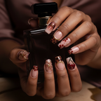 Dark skin hands holding perfume wearing burgundy floral cherry art custom press-on nails — LuxepressCo
