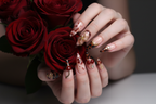 Fair-skin hands wearing dark cherry tortoiseshell stiletto gold flower custom press-on nails holding dark red roses — LuxepressCo