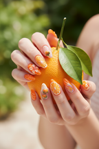 Fair skin hands wearing orange 3D floral citrus custom press-on nails holding fresh orange — LuxepressCo