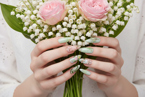 Light skin hands holding white lily bouquet wearing dragonfly garden custom press-on nails sage green — LuxepressCo