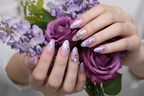 Light skin hands holding lavender wisteria bouquet wearing purple butterfly aurora custom press-on nails — LuxepressCo