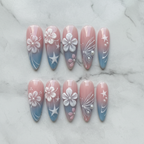 Flat lay top-down full set 10 custom press-on nails pink blue ombre 3D floral pearl butterfly studio — LuxepressCo