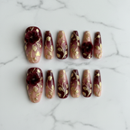 Flat lay top-down full set 10 burgundy gold 3D floral custom press-on nails white marble — LuxepressCo