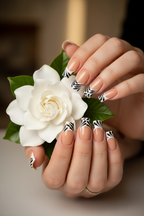 Fair-skin lifestyle nude peach black botanical swirl custom press-on nails holding white gardenia — LuxepressCo