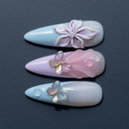Macro close-up 3D crystal butterfly charm and sculpted flower custom press-on nails pastel blue lavender — LuxepressCo