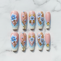 Flat lay top-down full set 10 blue 3D floral gold leaf pearl salon-quality nails white marble — LuxepressCo