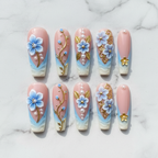 Flat lay top-down full set 10 blue 3D floral gold leaf pearl salon-quality nails white marble — LuxepressCo