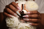 Lifestyle dark skin hands wearing romantic angel custom press-on nails holding white peonies — LuxepressCo