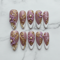 Flat lay top-down full set 10 mauve 3D flower gold baroque filigree French tip pearl salon-quality nails white marble — LuxepressCo